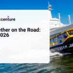 A water taxi sails in front of the historic SS Rotterdam ship under a clear blue sky, promoting the Secure Together on the Road: Rotterdam 2026 event.